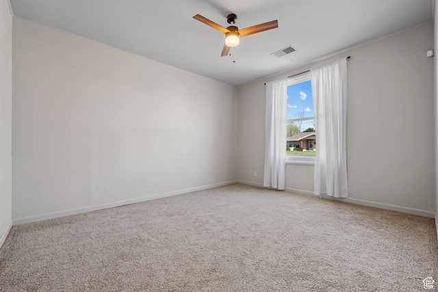 carpeted empty room with visible vents, baseboards, and ceiling fan
