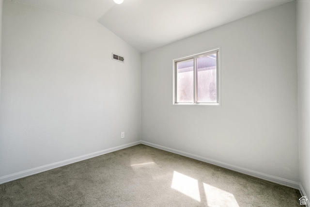 spare room with visible vents, baseboards, carpet, and vaulted ceiling
