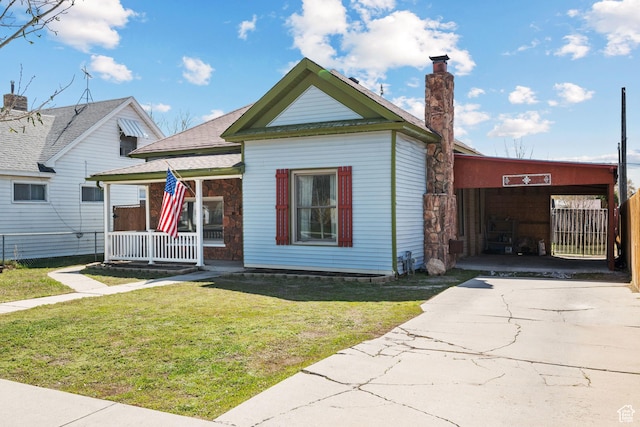bungalow-style home featuring a porch, driveway, a chimney, and a front lawn