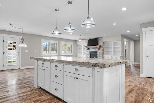 229 S 950 W, Springville, UT 84663 - kitchen with a ceiling fan, a stone fireplace, wood finished floors, white cabinetry, and hanging light fixtures