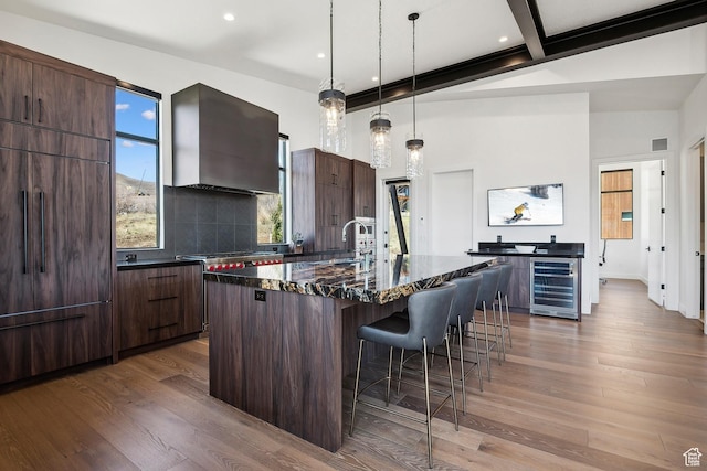 1526 W Orion Way, Heber City, UT 84032 - kitchen with a sink, modern cabinets, wall chimney exhaust hood, a breakfast bar, and beverage cooler