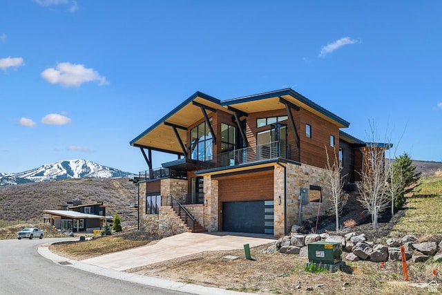 1526 W Orion Way, Heber City, UT 84032 - contemporary home with a balcony, a mountain view, stone siding, concrete driveway, and an attached garage