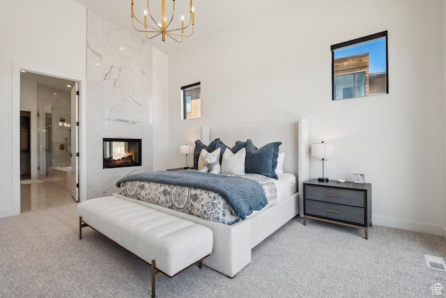 1526 W Orion Way, Heber City, UT 84032 - carpeted bedroom featuring connected bathroom, visible vents, a high end fireplace, baseboards, and an inviting chandelier