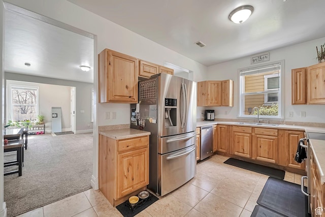 4911 W Calton Ln S, South Jordan, UT 84095 - kitchen with light colored carpet, visible vents, a healthy amount of sunlight, a sink, and stainless steel appliances