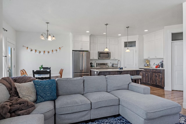 4444 W Lone Shadow Ln, Herriman, UT 84096 - living room with recessed lighting, an inviting chandelier, and wood finished floors