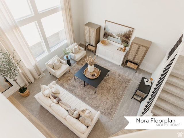 living area with baseboards, a high ceiling, and stairs