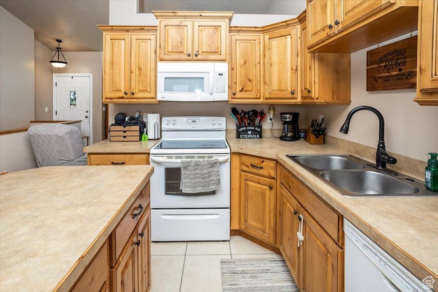 kitchen with a sink, light countertops, white appliances, and light tile patterned flooring