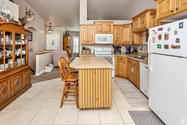 kitchen with light tile patterned floors, a center island, a sink, light countertops, and white appliances