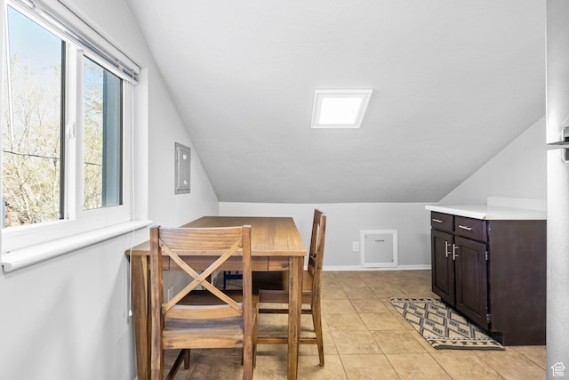 dining space with light tile patterned floors and vaulted ceiling