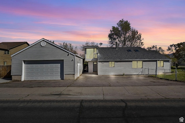 view of front of home featuring fence, a garage, and aphalt driveway