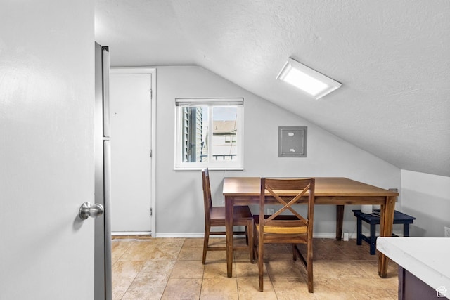 dining room featuring electric panel, baseboards, vaulted ceiling, and a textured ceiling