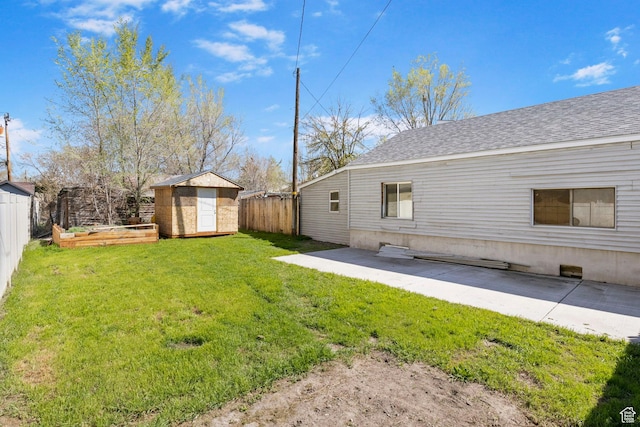 view of yard with a storage shed, a fenced backyard, a patio area, and an outbuilding