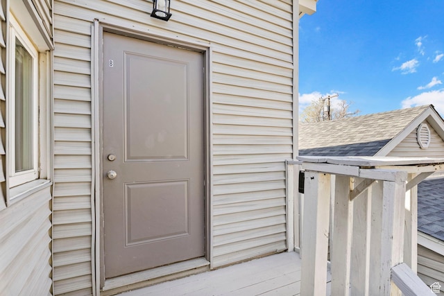 entrance to property with roof with shingles