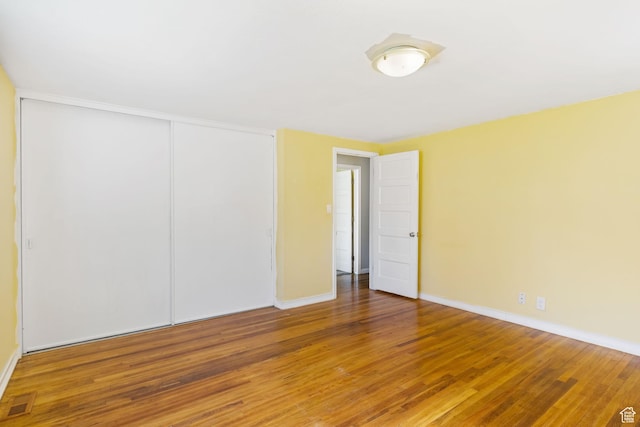 spare room featuring wood finished floors, baseboards, and visible vents