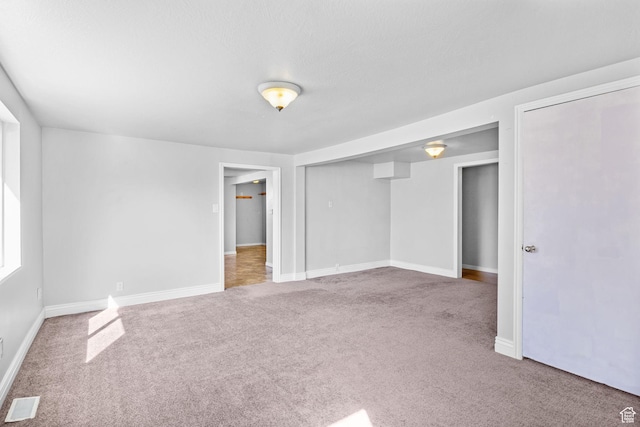 unfurnished bedroom featuring visible vents, baseboards, and carpet floors
