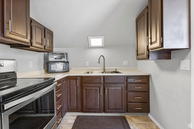 kitchen featuring electric stove, light countertops, a sink, and dark brown cabinetry