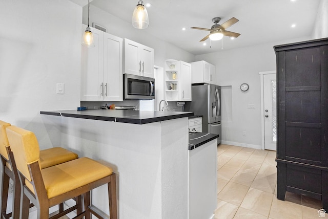 kitchen with a breakfast bar, open shelves, dark countertops, ceiling fan, and stainless steel appliances