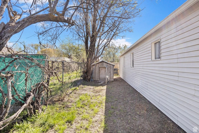 view of yard featuring fence, an outdoor structure, and a shed