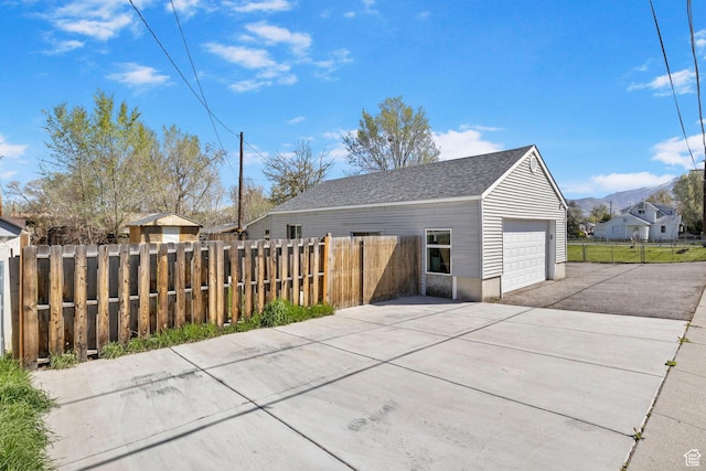 garage featuring a mountain view, fence, and driveway