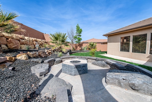 view of patio featuring a fenced backyard and an outdoor fire pit