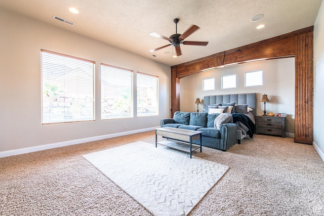 living room featuring ceiling fan, carpet, a textured ceiling, visible vents, and baseboards