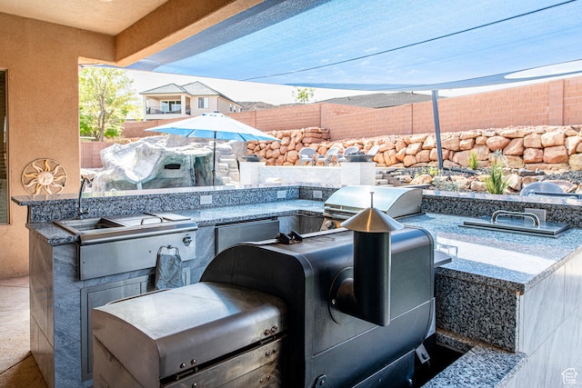 view of patio / terrace featuring area for grilling, a grill, and fence