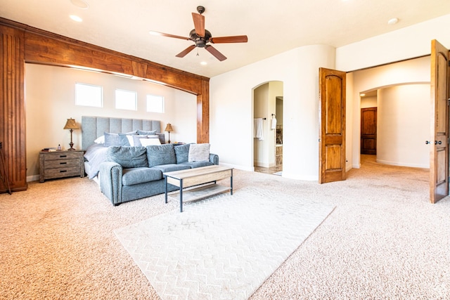 bedroom featuring light carpet, arched walkways, baseboards, and recessed lighting