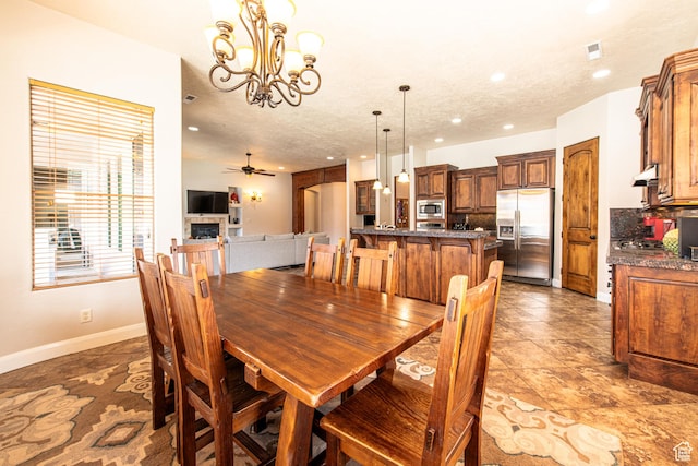 tiled dining space featuring visible vents, baseboards, a fireplace, recessed lighting, and ceiling fan with notable chandelier