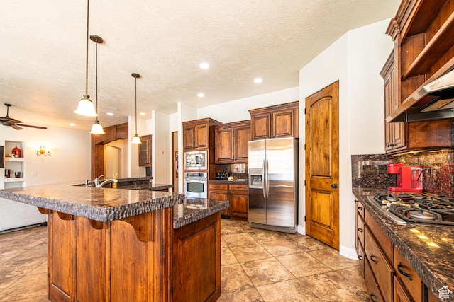 kitchen with decorative backsplash, appliances with stainless steel finishes, a breakfast bar, and a textured ceiling