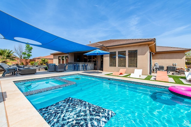 view of swimming pool with an outdoor living space with a fire pit, outdoor dry bar, a patio area, and a pool with connected hot tub