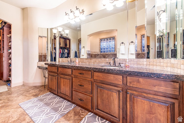 full bathroom with tasteful backsplash, double vanity, visible vents, and a sink