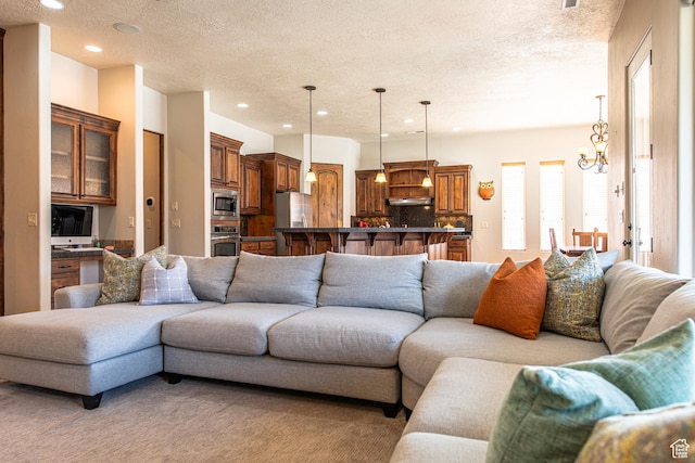 living area with recessed lighting, light colored carpet, and a textured ceiling