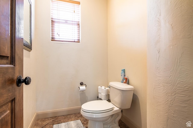 bathroom with toilet, tile patterned floors, and baseboards