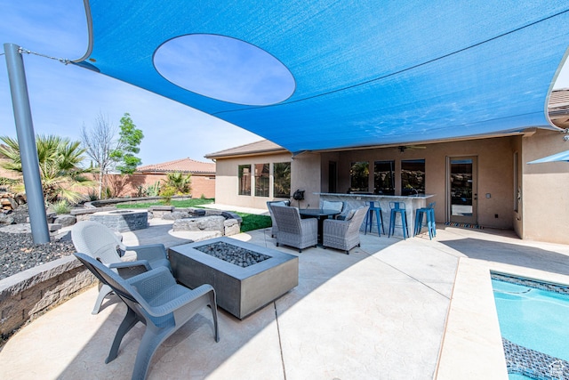 view of patio / terrace featuring outdoor dry bar, fence, and an outdoor fire pit