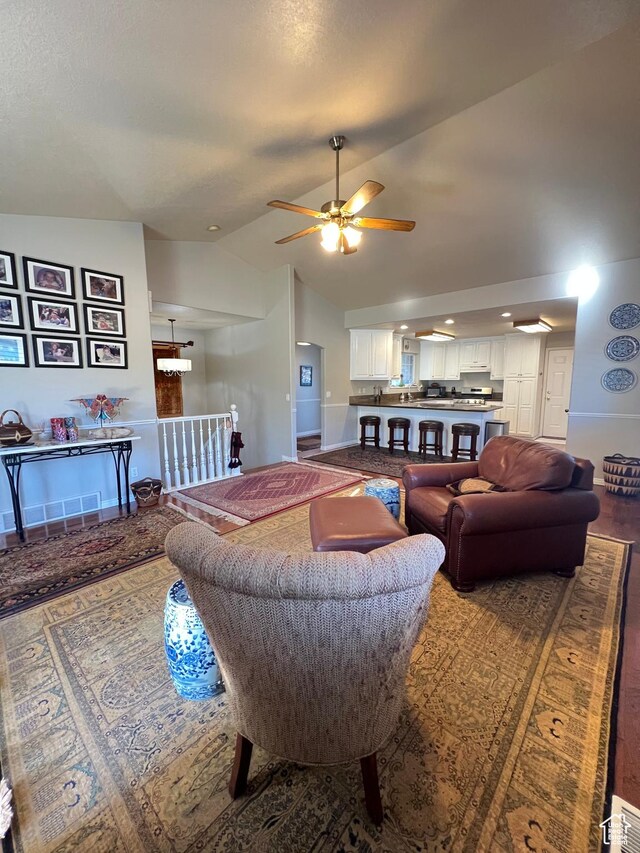living room featuring high vaulted ceiling, baseboards, and a ceiling fan