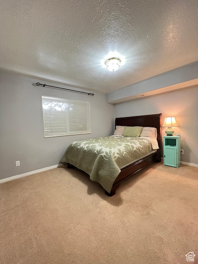bedroom featuring a textured ceiling, baseboards, and carpet floors