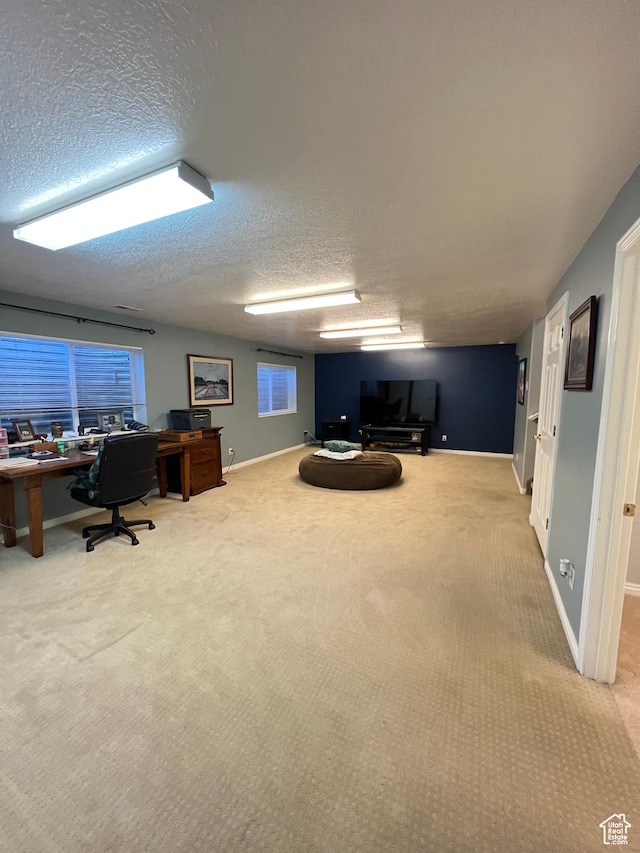 carpeted office with baseboards and a textured ceiling