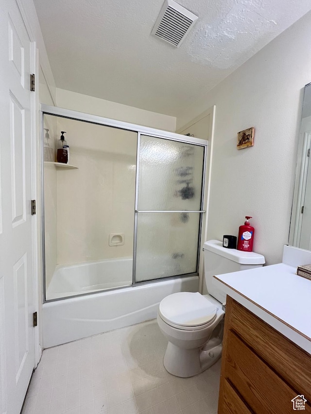 full bath with a textured ceiling, vanity, visible vents, toilet, and combined bath / shower with glass door