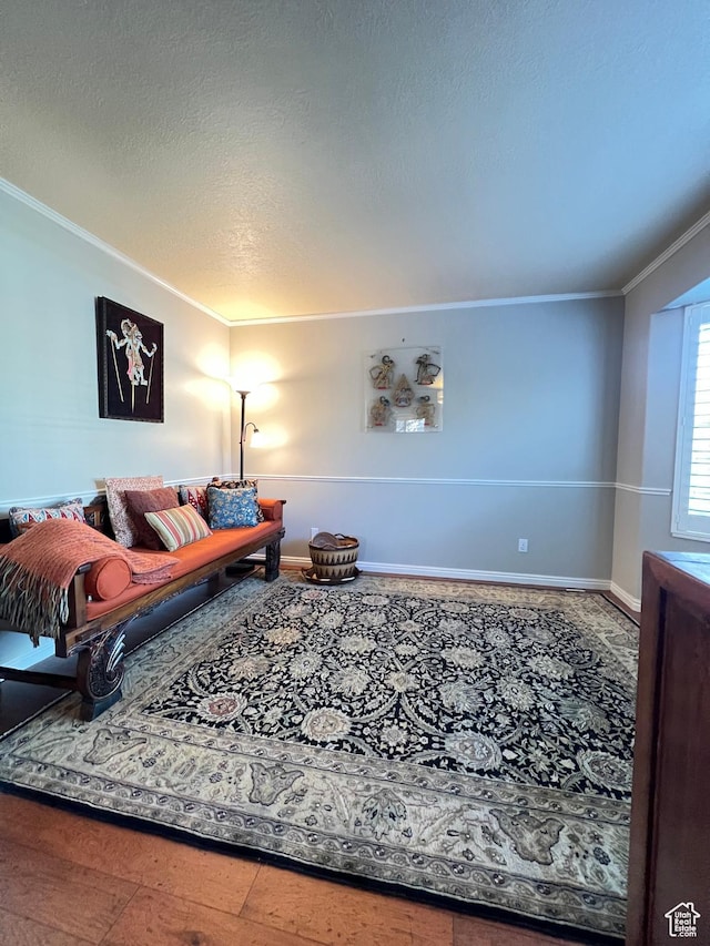 living room with baseboards, a textured ceiling, and crown molding