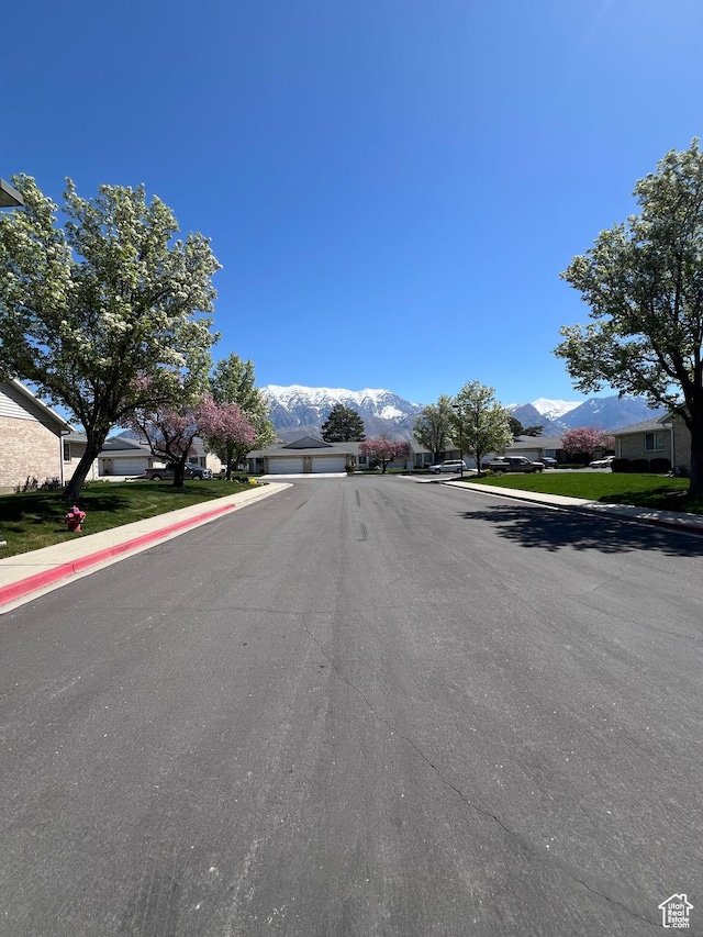 view of street featuring sidewalks, a mountain view, and curbs