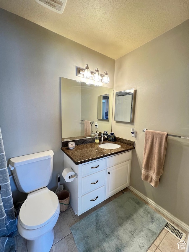 bathroom featuring vanity, tile patterned flooring, a textured ceiling, toilet, and visible vents