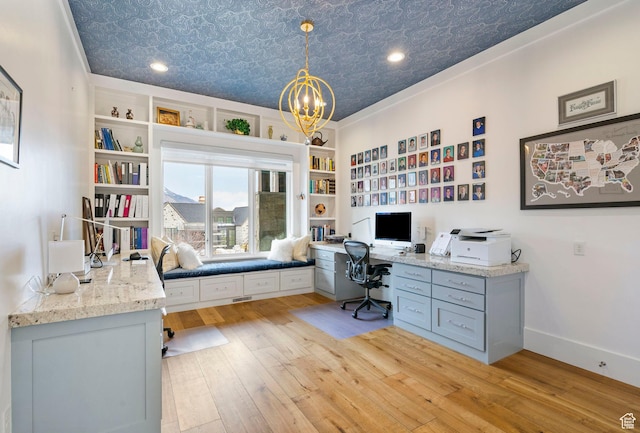 office area featuring a notable chandelier, light wood-type flooring, baseboards, built in study area, and an ornate ceiling