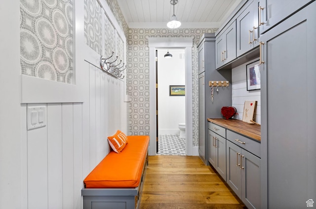 mudroom with crown molding, baseboards, wood finished floors, and wood ceiling