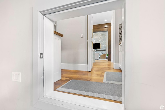 hall with baseboards and wood finished floors