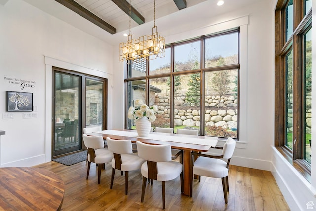 dining space with beam ceiling, baseboards, plenty of natural light, and a notable chandelier
