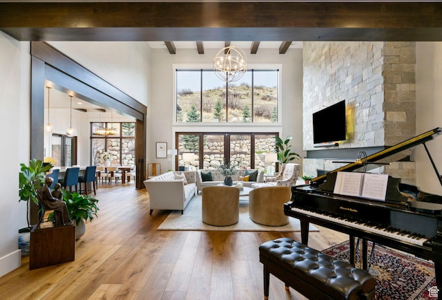 living room featuring a high ceiling, an inviting chandelier, wood-type flooring, and beamed ceiling