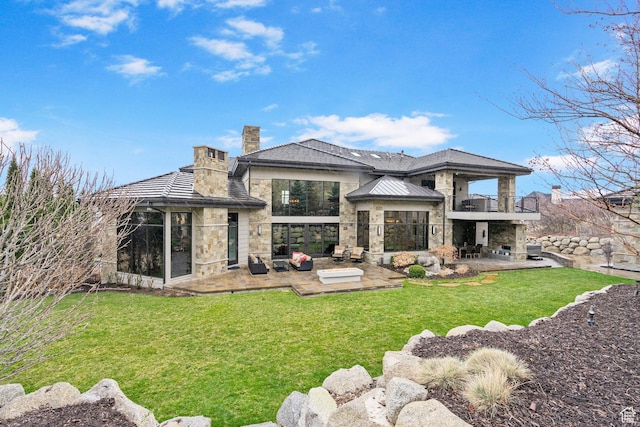 back of house featuring a yard, a patio area, a gazebo, stone siding, and a chimney