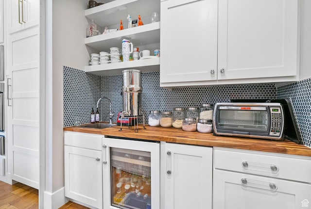 bar featuring beverage cooler, wet bar, wood finished floors, backsplash, and a toaster