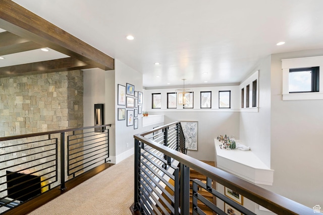 hallway featuring a healthy amount of sunlight, an upstairs landing, and recessed lighting
