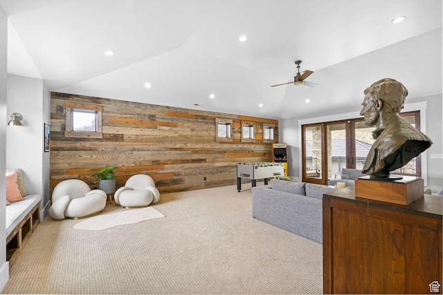 living room with lofted ceiling, recessed lighting, carpet flooring, wooden walls, and ceiling fan